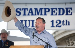 Jason Kenney raising cowboy hat in the air