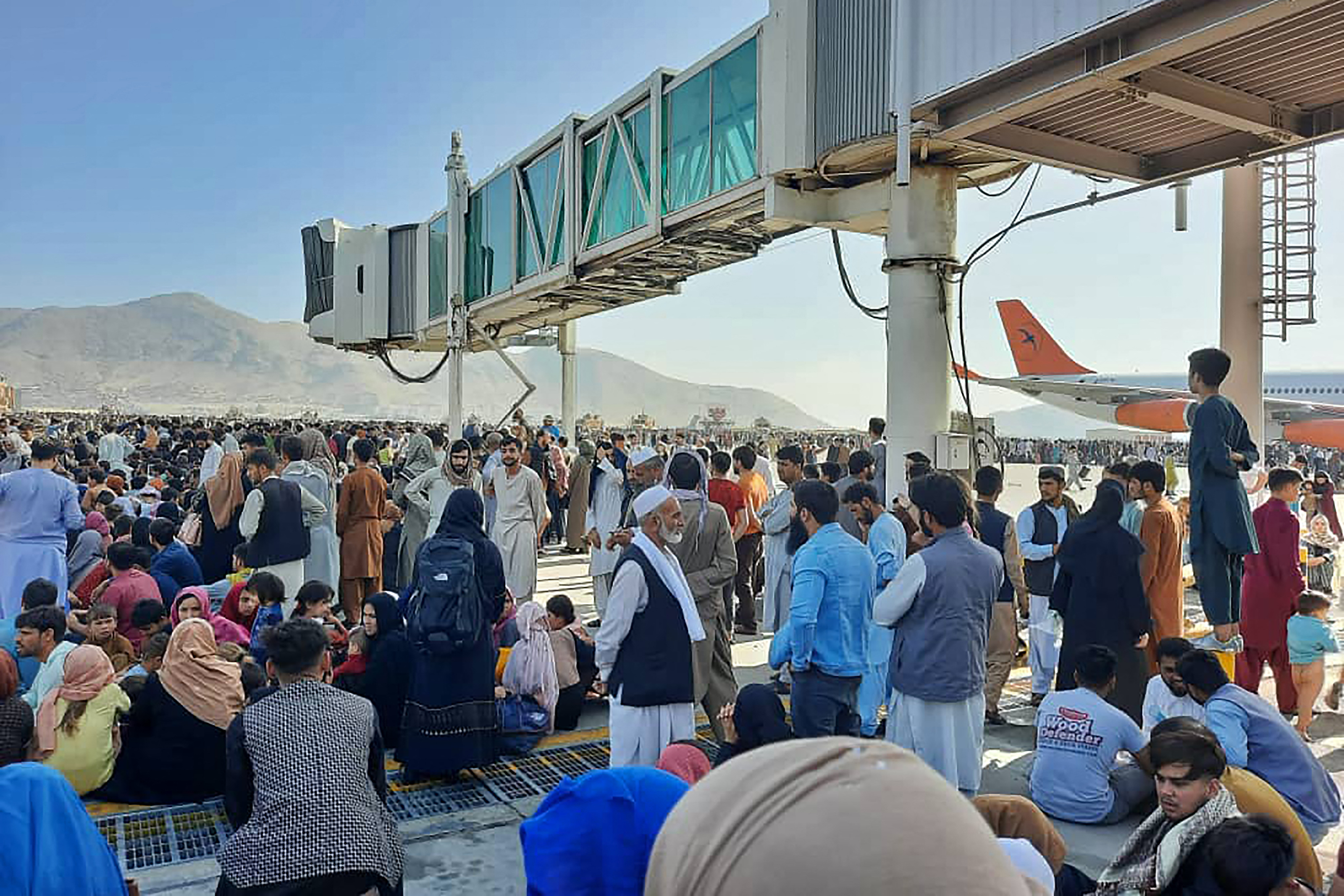 People crowd the tarmac at Kabul's airport, waiting to board flights out of the country. Photo: AFP via Getty Images