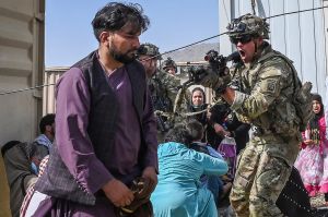 A US soldier points his gun towards an Afghan passenger at Kabul airport on the 16th of August as thousands of people mobbed the city's airport trying to flee the Taliban. Photo: Wakil KOHSAR / AFP