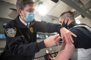 A member of the New York Police Department (NYPD) receives a dose of the Moderna Covid-19 vaccination at Queens Police Academy in the Queens borough of New York, U.S., on Monday, Jan. 11, 2021.