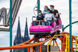 Eine Gruppe Jugendlicher in Köln auf der Achterbahn. Die Grünen-Politikerinnen Jamila Schäfer und Ricarda Lang wollen, dass junge Leute künftig bevorzugt behandelt werden, wenn es um Corona-Maßnahmen geht.