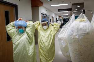 Healthcare workers putting on PPE to help COVID-19 patient