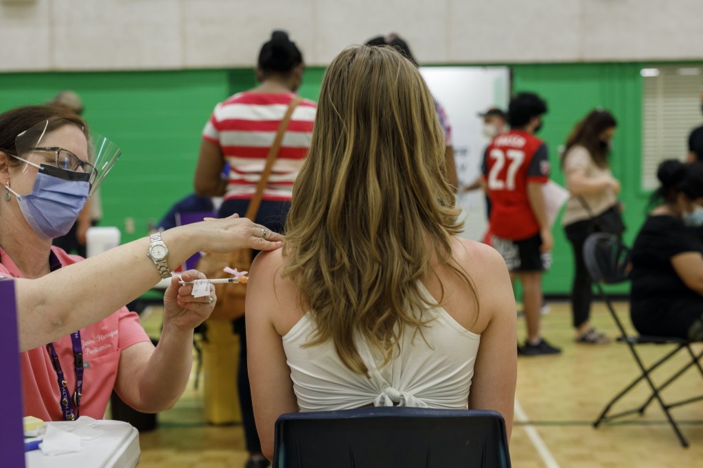 ​A student gets a dose of the Pfizer vaccine at a Toronto clinic.