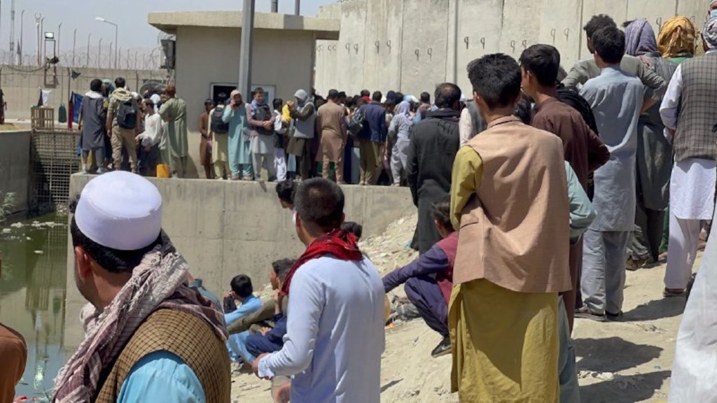 People wanting to leave Afghanistan continue to wait around Hamid Karzai International Airport in Kabul Thursday.