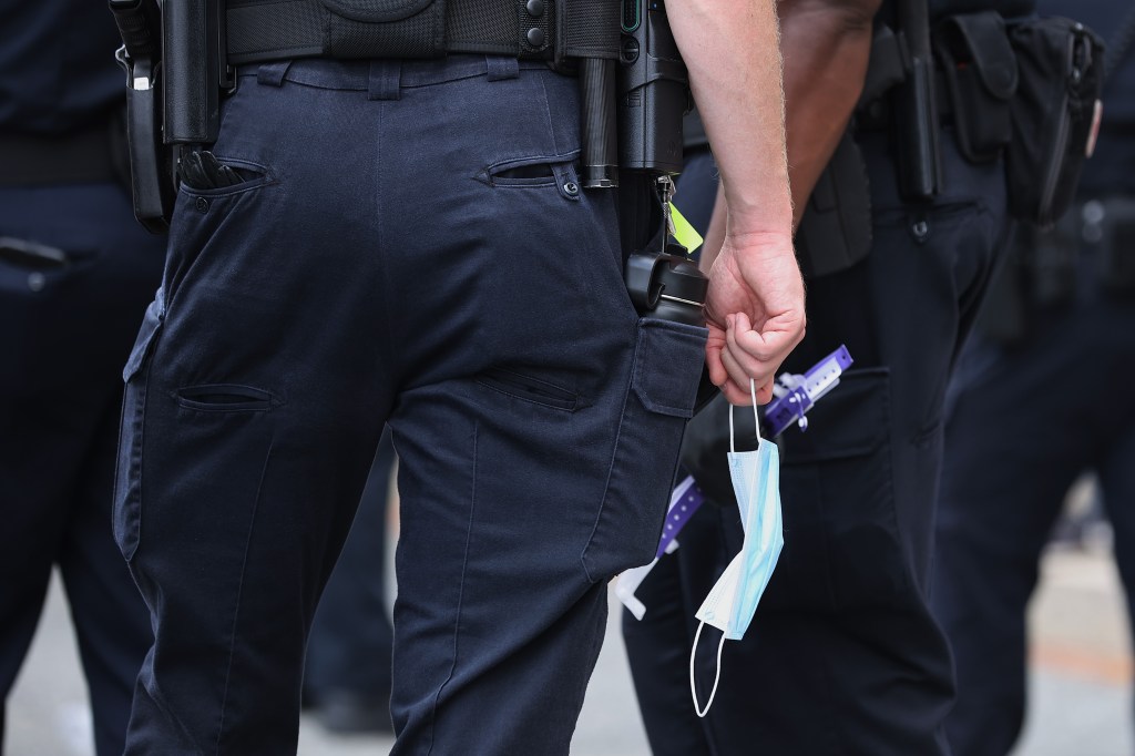 Police officer holding a mask.