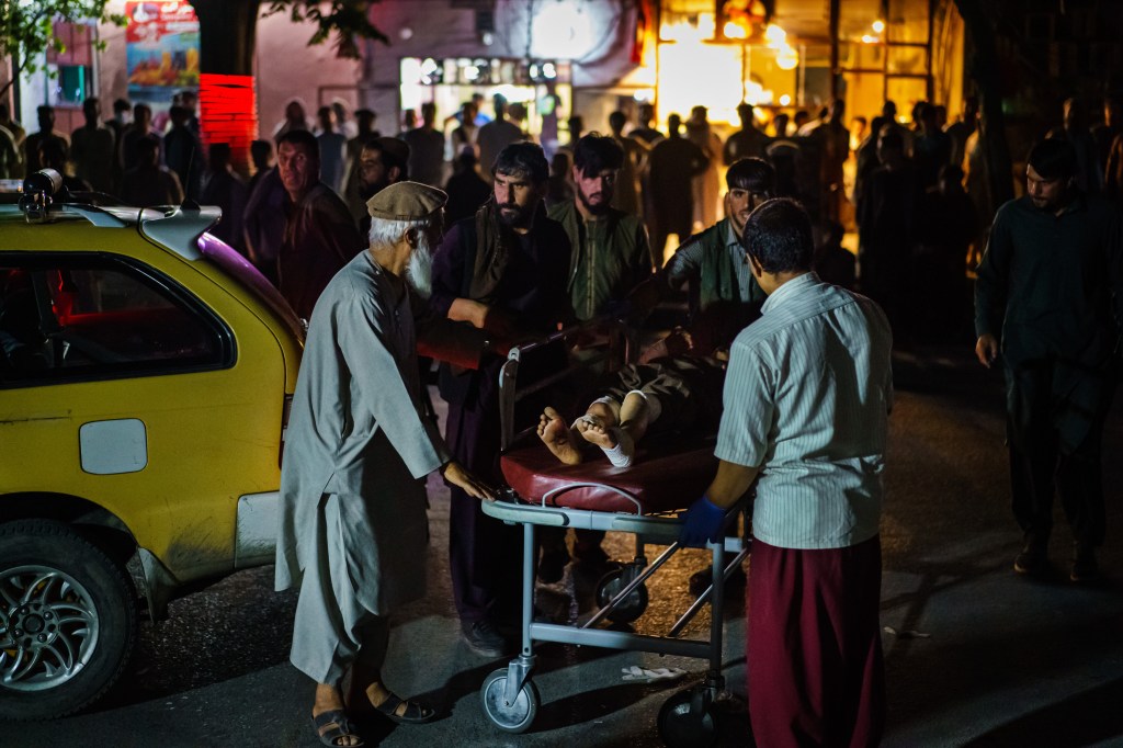 Een gewonde wordt met een taxi naar het ziekenhuis gebracht na een bomaanslag op het vliegveld in Kabul, Afgha