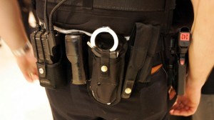 A cop's waistband with a gun and handcuffs.