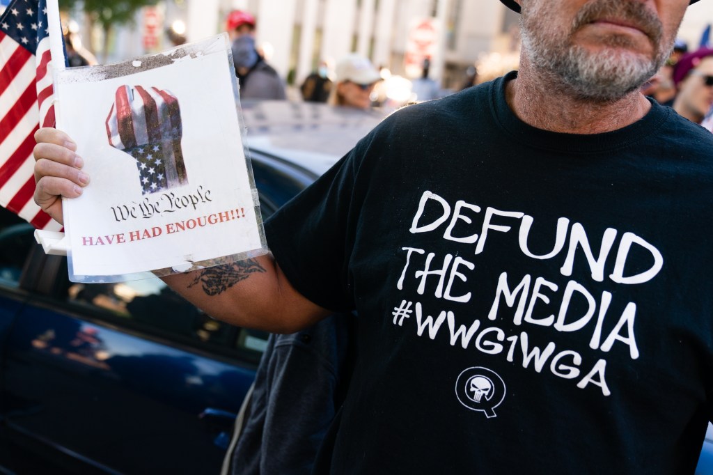 A man wearing a 'Defund the Media' QAnon shirt is seen at a "Stop the Steal" rally against the results of the U.S. Presidential election outside the Georgia State Capitol on November 18, 2020 in Atlanta, Georgia. (Photo by Elijah Nouvelage/Getty Images)