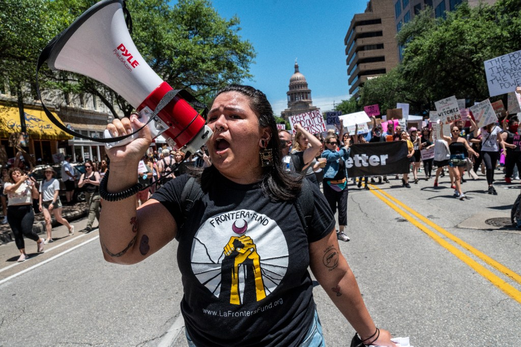 Protesters hold up signs as they march down Congress Ave at a protest outside the Texas state capitol on May 29, 2021 in Austin, Texas. (Sergio Flores/Getty Images)​