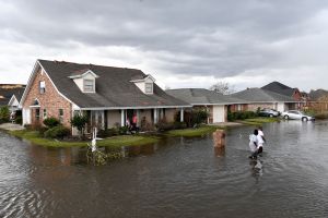 Residents wade through flood waters after their neighborhood flooded in LaPlace, Louisiana on August 30, 2021 in the aftermath of Hurricane Ida.