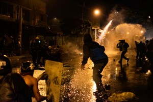 Demonstrators use fireworks against Colombia's riot police in late-night clashes during the country's protest movement this year.