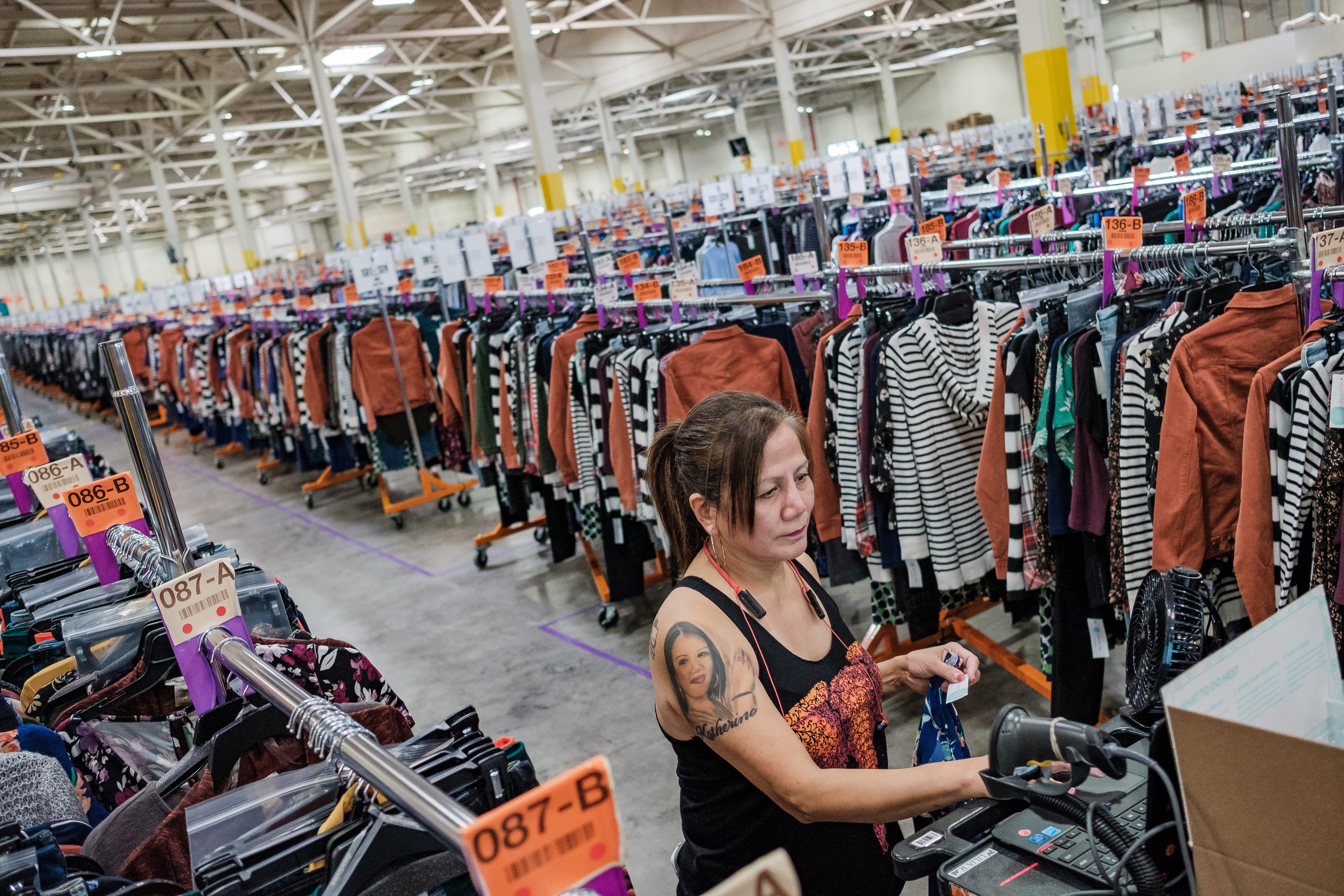 An Employee uses a computer and scanner on top of a cart to pull clothing at one Stitch Fix's warehouses, in South San Francisco