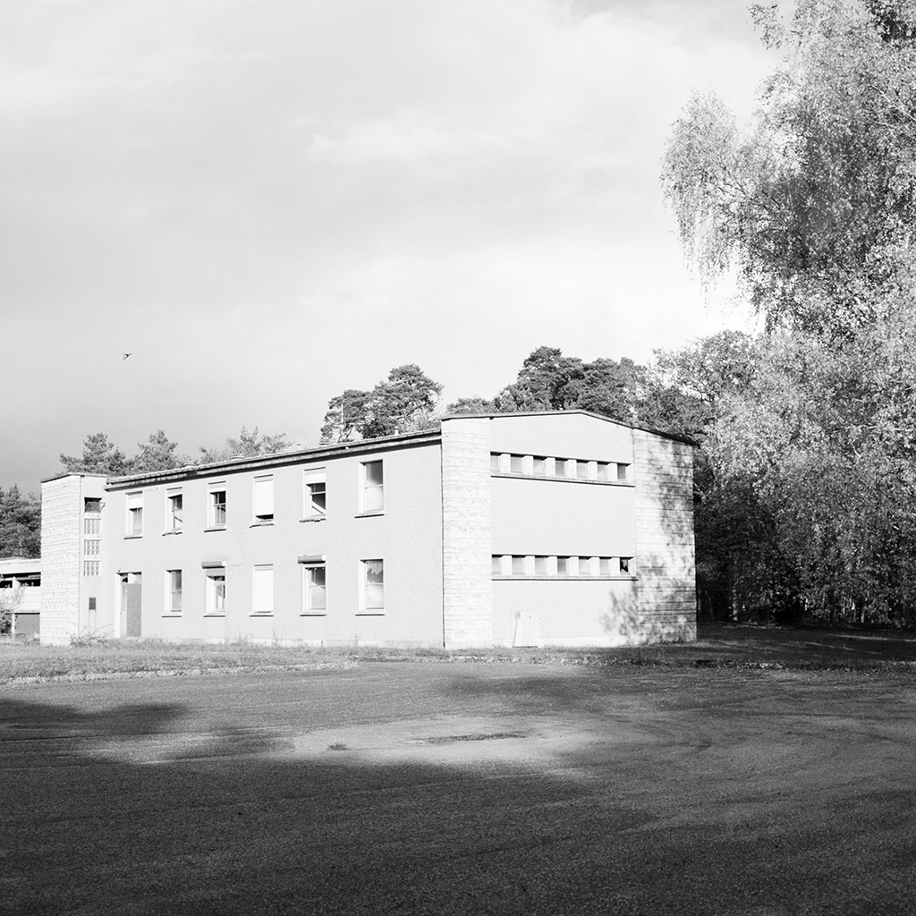 Mathias de Lattre, France, magic mushrooms - black and white image of austere institutional building atop a grass lawn.