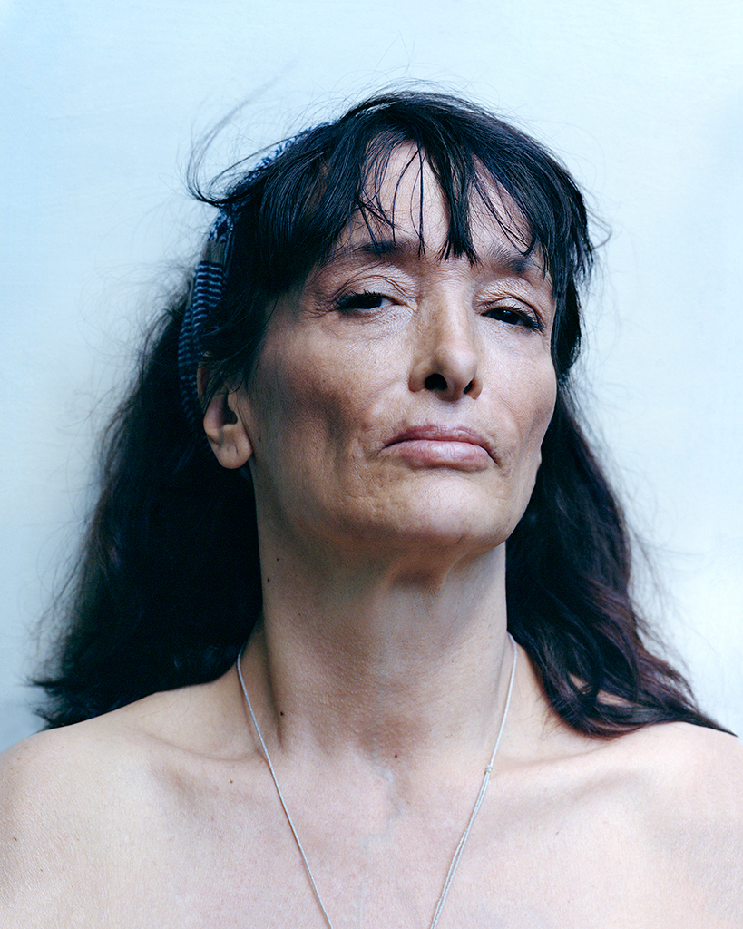 Mathias de Lattre, France, magic mushrooms - Colour photo of the photographer's black haired, topless mother against a very pale blue background.