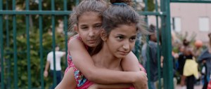 Two young girls embrace outside in the film 'You Resemble Me'