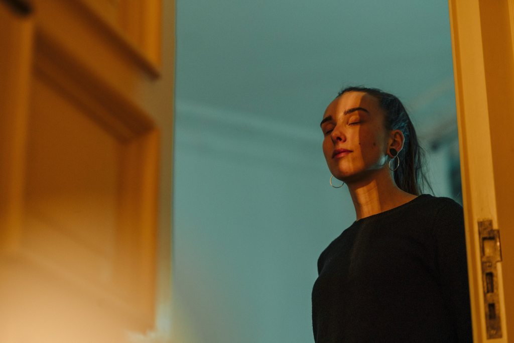 A woman stands in a doorway. Photo: Westend61