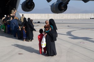 In this handout provided by U.S. Central Command Public Affairs, U.S. Air Force loadmasters and pilots assigned to the 816th Expeditionary Airlift Squadron, load passengers aboard a U.S. Air Force C-17 Globemaster III in support of the Afghanistan evacuat