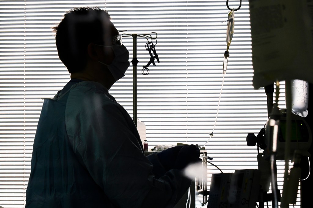 East Alabama Medical Center nurse Harvard Graham checks fluids for a COVID-19 patient in the intensive care unit Thursday, Dec. 10, 2020, in Opelika, Ala. (AP Photo/Julie Bennett)​