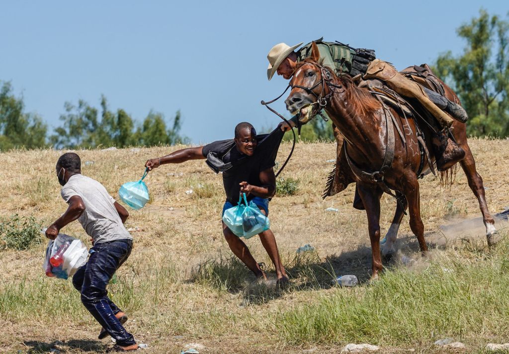 Un agente de la Patrulla Fronteriza Montada de los Estados Unidos intenta evitar que un migrante haitiano ingrese a un campamento a orillas del Río Bravo, cerca del puente internacional de Del Río, Texas, el 19 de septiembre de 2021.