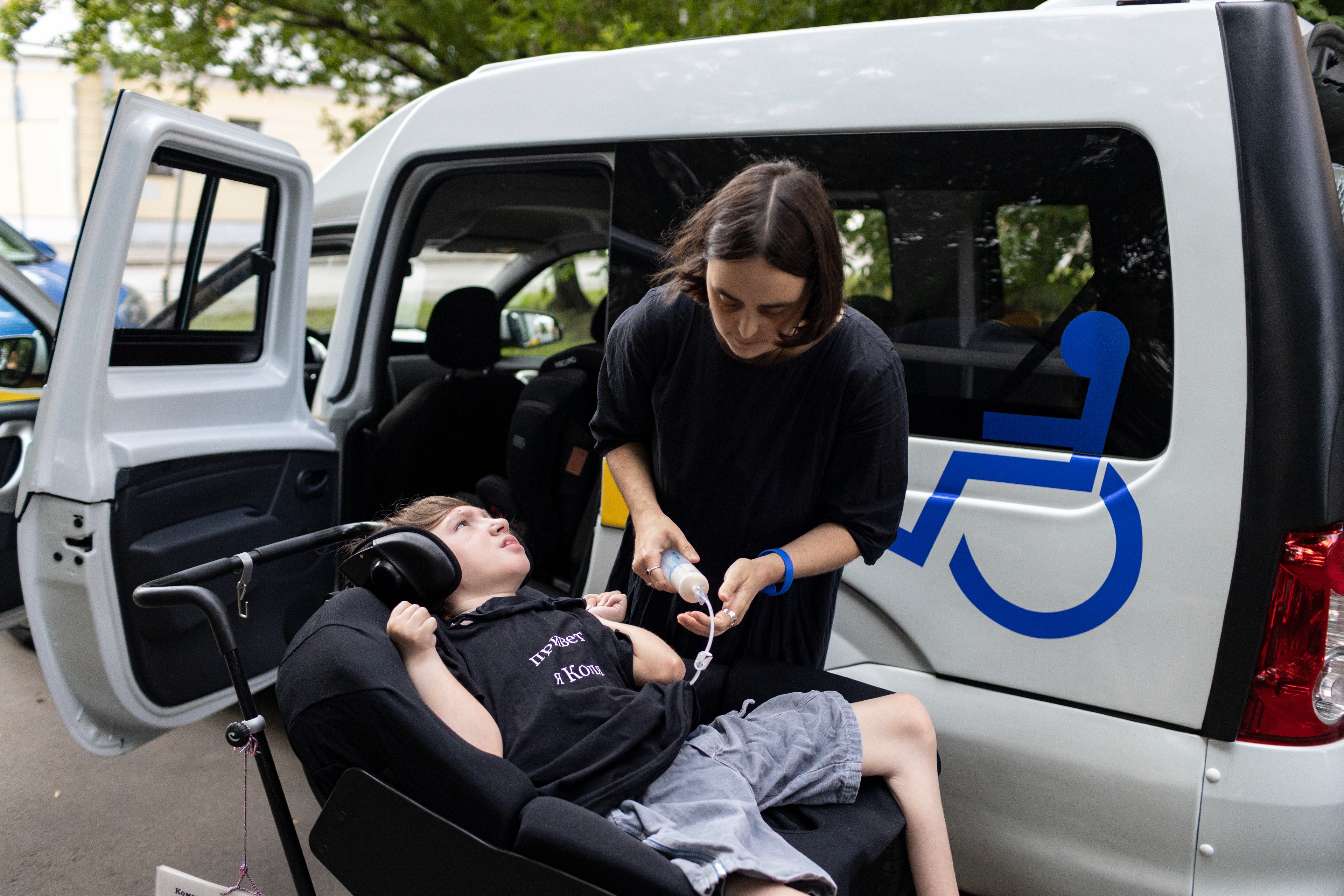 LIDIA MONIAVA FEEDS KOLYA BEFORE THEY GET IN A TAXI IN MOSCOW.