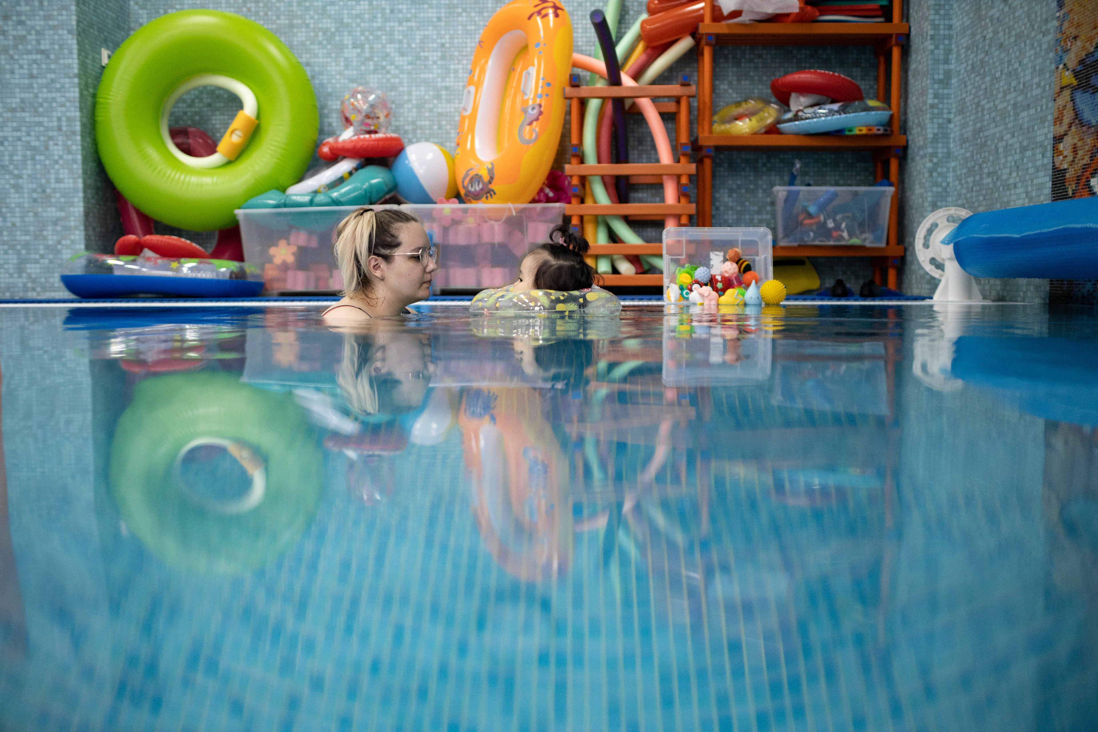 A VOLUNTEER SWIMS WITH A LITTLE GIRL IN A SWIMMING POOL AT THE LIGHTHOUSE CHILDREN’S HOSPICE IN MOSCOW, RUSSIA.