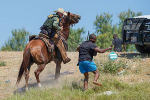 A United States Border Patrol agent on horseback uses the reins to try and stop a Haitian migrant from entering an encampment on the banks of the Rio Grande near the Acuna Del Rio International Bridge in Del Rio, Texas on September 19, 2021.