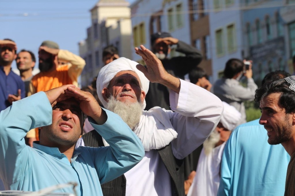 Civiles observan mientras los talibanes cuelgan los cadáveres de cuatro personas asesinadas por cargos de secuestro en la plaza principal de Herat, Afganistán