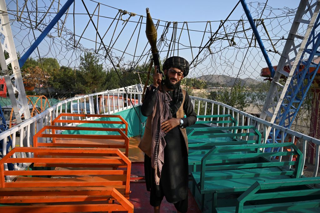 A Taliban fighter holding a rocket launcher stands on a pirate ship ride at a fairground at Qargha Lake on the outskirts of Kabul. All photos: WAKIL KOHSAR/AFP via Getty Images