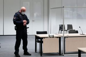 A judicial officer looks at his watch prior to a trial against a 96-year-old former secretary for the SS commander of the Stutthof concentration camp at the court room in Itzehoe, northern Germany, on September 30, 2021. Photo: Markus Schreiber / POOL / A