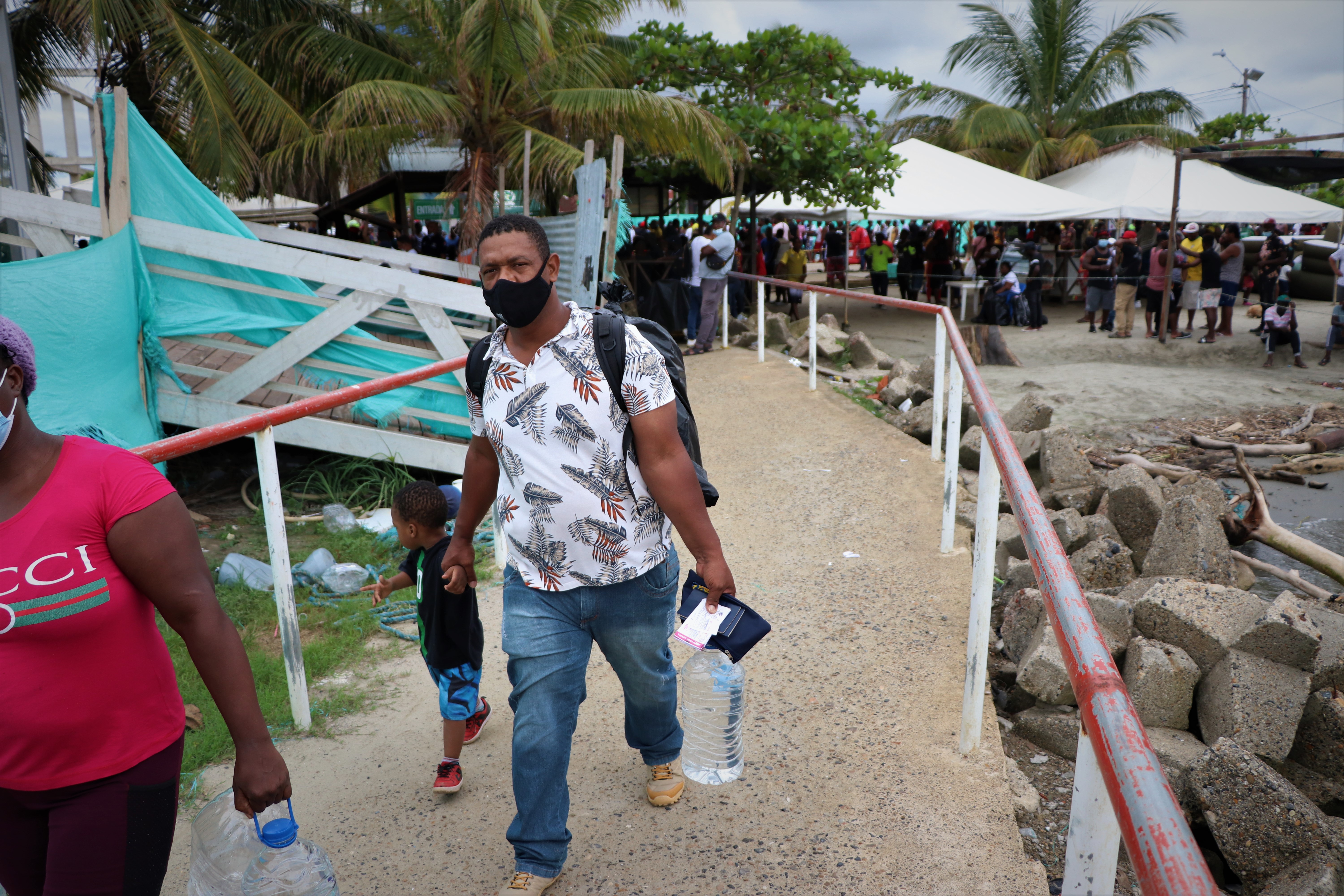 Edouanier Simon and his youngest son walk to the boat that will take them across the Gulf of Urabá where they will begin a trek through the Darien Gap. .JPG