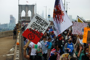 Hundreds gather outside the Department of Education in Brooklyn and march across the Brooklyn Bridge to protest vaccination mandate during "Freedom Rally" in New York City, United States on October 4, 2021. (Tayfun Coskun/Anadolu Agency via Getty Images)​