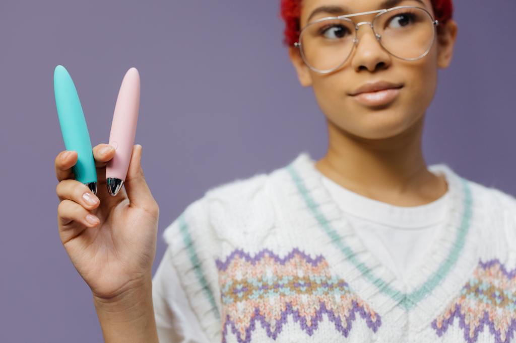 Someone holding up two vibrators. Photo by cottonbro from Pexels