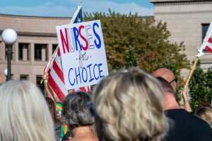 Protest sign reads "nurses for choice" in red white and blue.