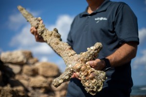 Jacob Sharvit, director of the Marine Archaeology Unit of the Israel Antiquities Authority holds a meter-long (yard-long) sword, that experts say dates back to the Crusaders.