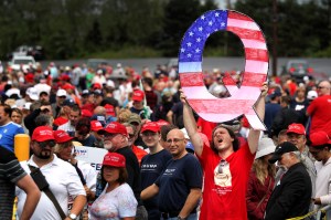 A man holds up a large "Q" sign while waiting to see former President Donald J. Trump at his rally on August 2, 2018 in Pennsylvania.