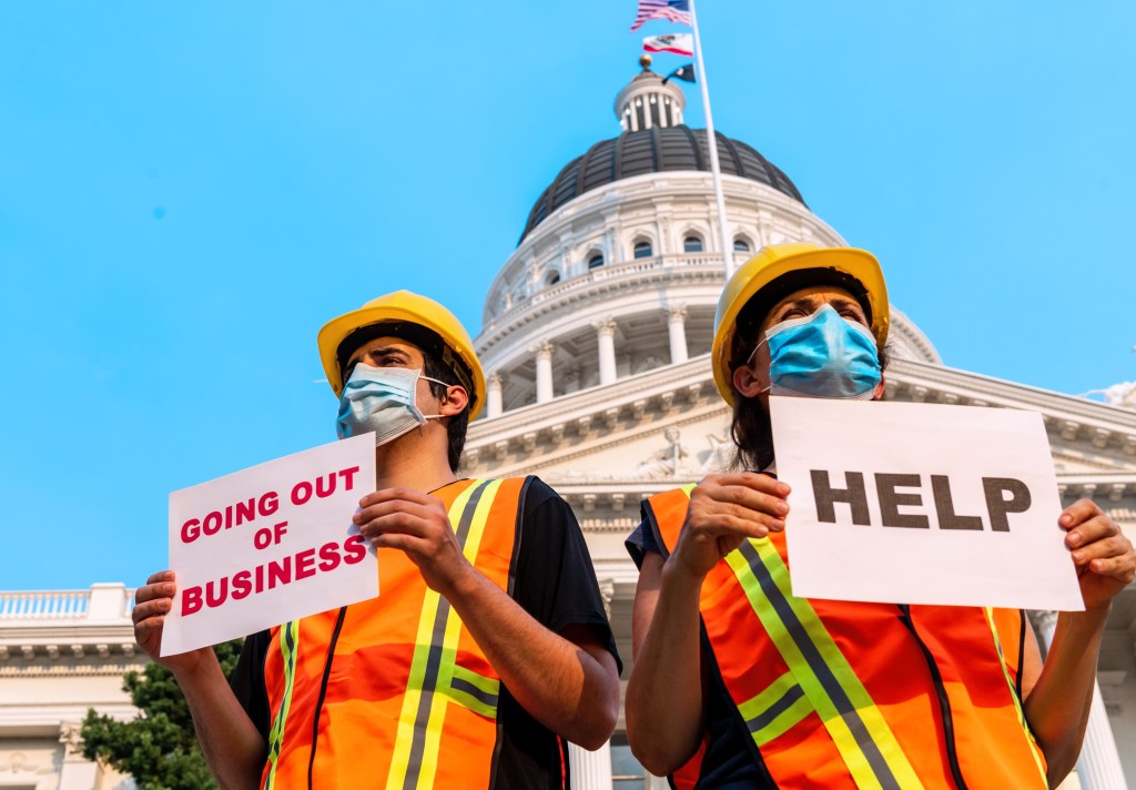 Workers in front of the Capitol wearing masks and holding strike signs.