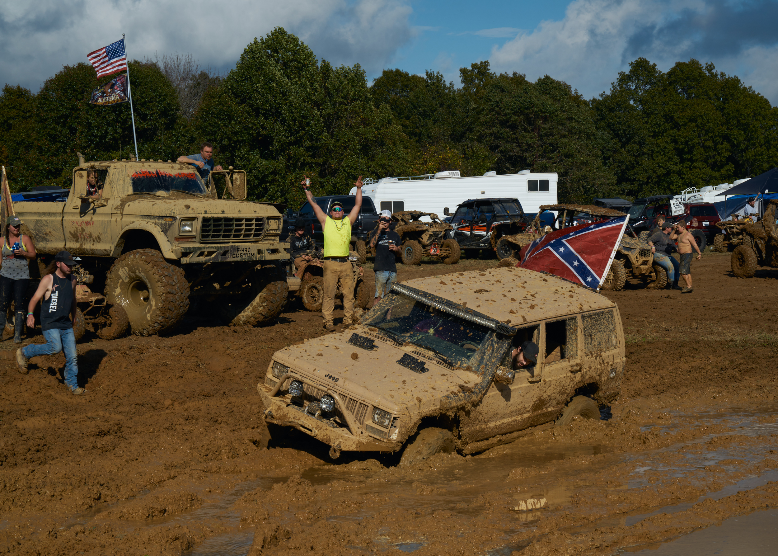 Ein verdreckter Geländewagen mit Konföderiertenflagge ist im matschigen Untergrund steckengeblieben, im Hintergrund jubeln mehrere Leute