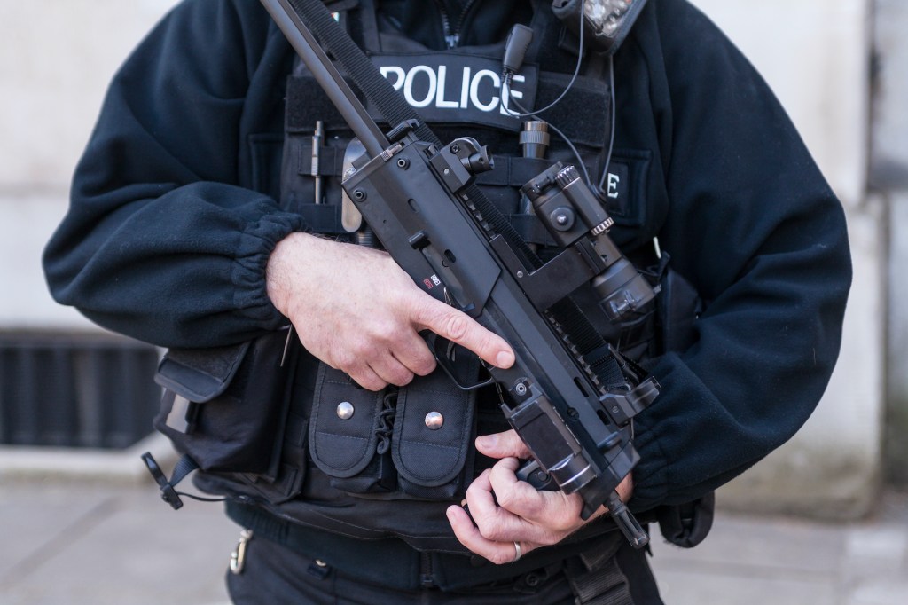 ​A police officer holding a gun