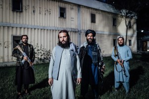 Adrien Vautier, Afghanistan – Four men posing in front of a house in traditional gear, three of them holding weapons