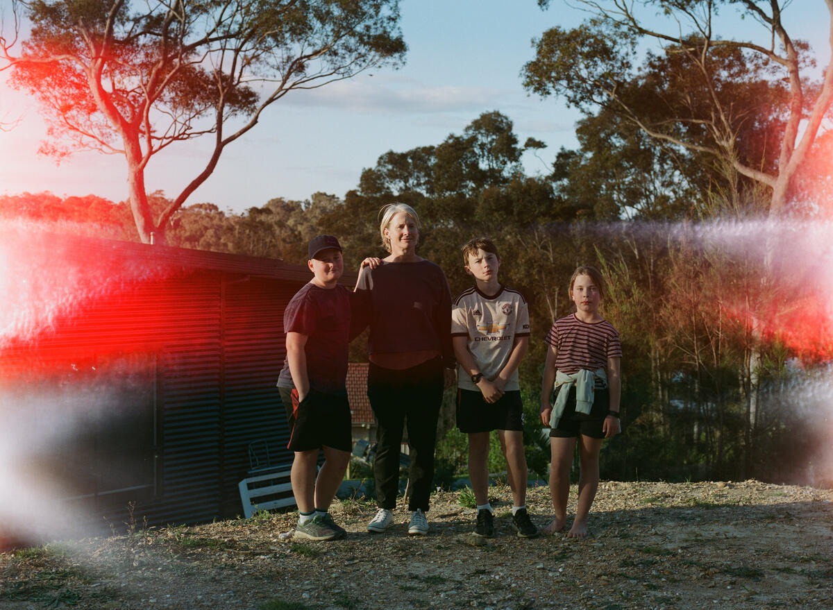 Left to right: Harry 11, Margie, 46, Oscar, 13, Romy, 9, in the backyard of their family home. Image: Matthew Abbott / Save the Children