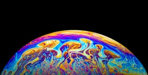 Close up of a soap bubble with psychedelic color on black background