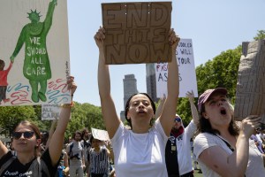 Demonstrators hold signs and gather during a protest against the Trump administration's policy on separating immigrant families in the Brooklyn borough of New York, U.S., on Sunday, June 30, 2018. (Cedric von Niederhausern/Bloomberg via Getty Images​)