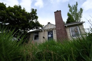 An empty house with an overgrown yard on North Maryland Avenue in the Interstate Corridor of Portland, Ore., is pictured with a Bureau of Developmental Services (BDS) Nuisance Notice taped to the outside of the front door, on May 14, 2019. (Alex Milan Tra