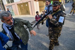 A member of the Taliban pushes a journalist (L) covering a demonstration by women protestors in Kabul on 30th September, 2021. Photo: BULENT KILIC / AFP​