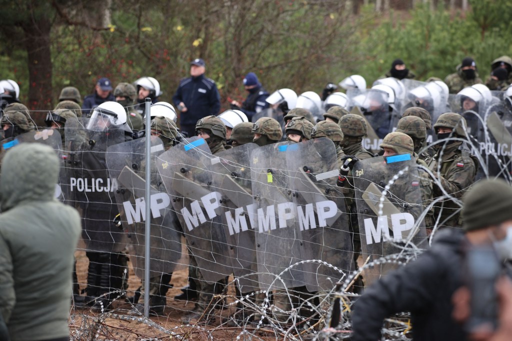 Poland's law enforcement officers watching migrants at the Belarusian-Polish border.