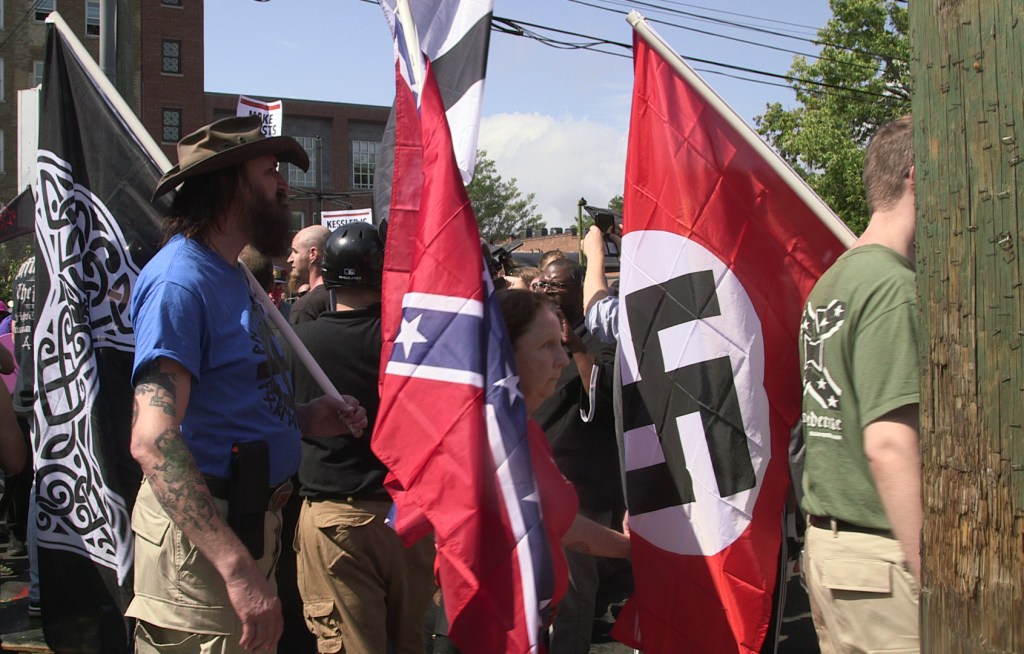 Demonstrators carry confederate and Nazi flags during the Unite the Right free speech rally at Emancipation Park in Charlottesville, Virginia, USA on August 12, 2017.