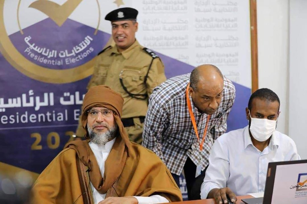 Saif al-Islam (left) registers his candidacy for the country's presidential elections. Photo: Libyan High National Elections Commission via AP