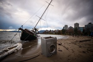 sailboat that was blown ashore on English Bay in Vancouver during flooding eventCP141334570