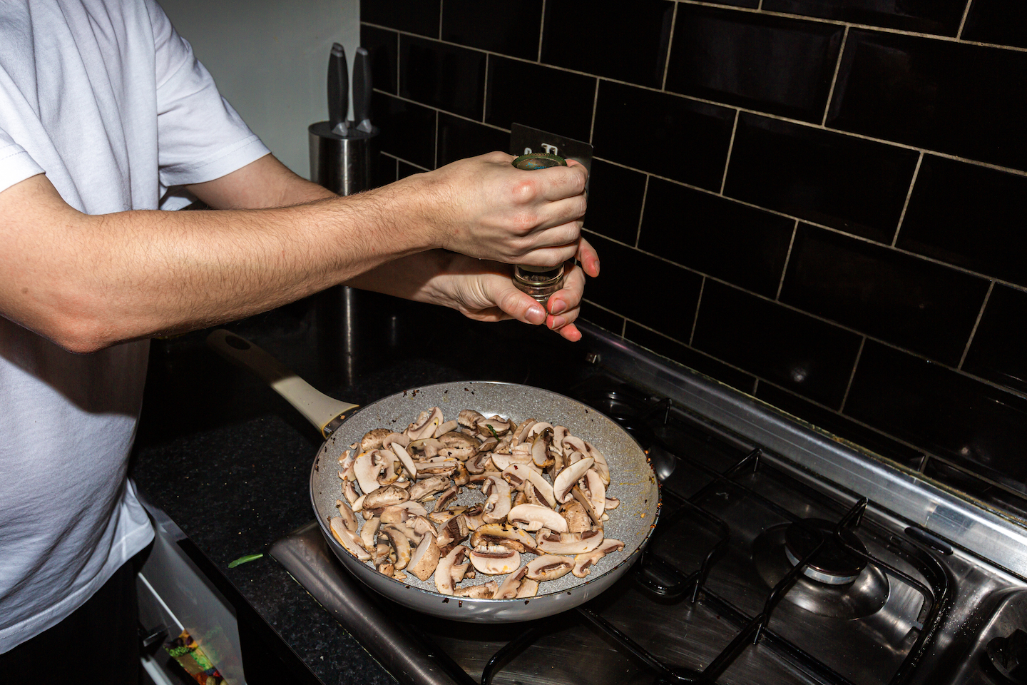 The author grates pepper onto mushrooms