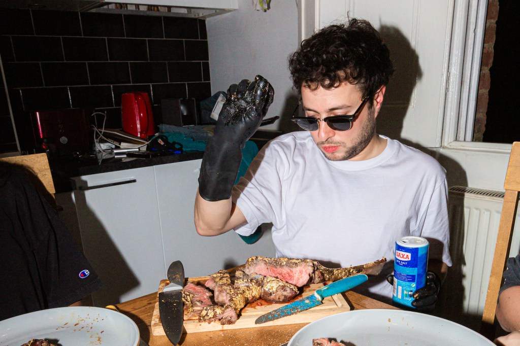 The author dressed as Salt Bae sprinkling salt on a steak